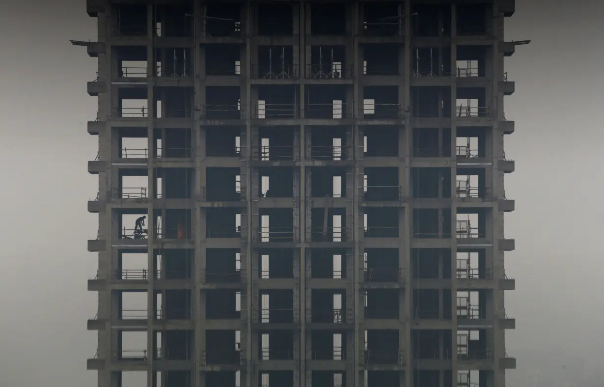 FILE PHOTO: A labourer works on a construction site of a residential building during a hazy day in Hangzhou