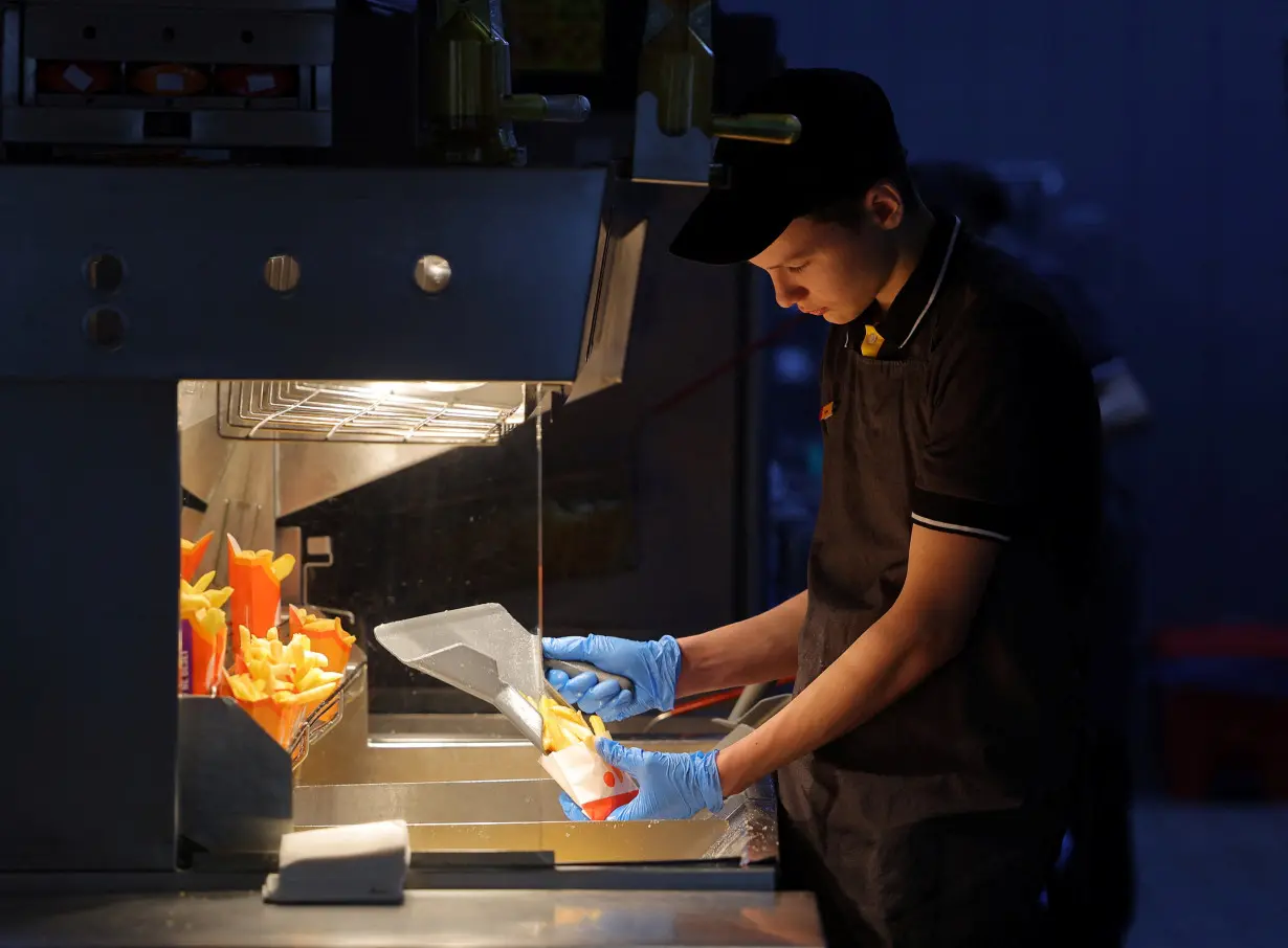 An employee cooks fries at the Vkusno & tochka fast food restaurant in Moscow