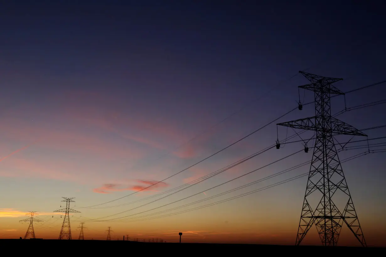 FILE PHOTO: The sun sets behind power lines above the plains north of Amarillo, Texas