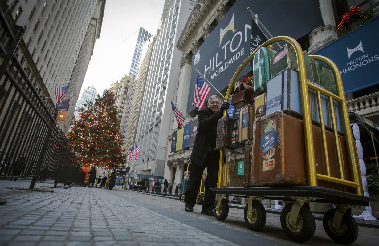 A Hilton employee pushes a luggage cart in front of the the New York Stock Exchange to celebrate of the company's IPO