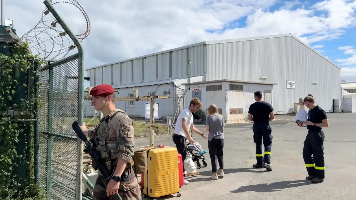 Evacuees arrive at the airport in Noumea