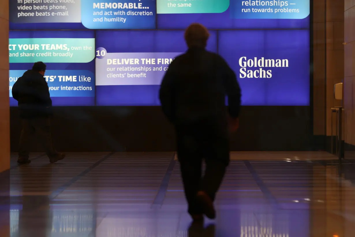 FILE PHOTO: People walk in the Goldman Sachs global headquarters in Manhattan, New York