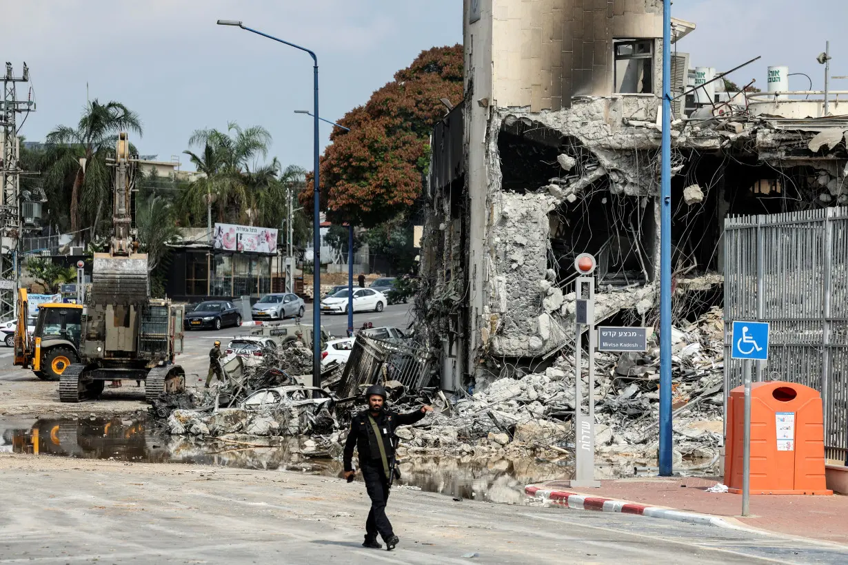 A member of Israel's security walks past a police station following a mass infiltration by Hamas gunmen from the Gaza Strip, in Sderot