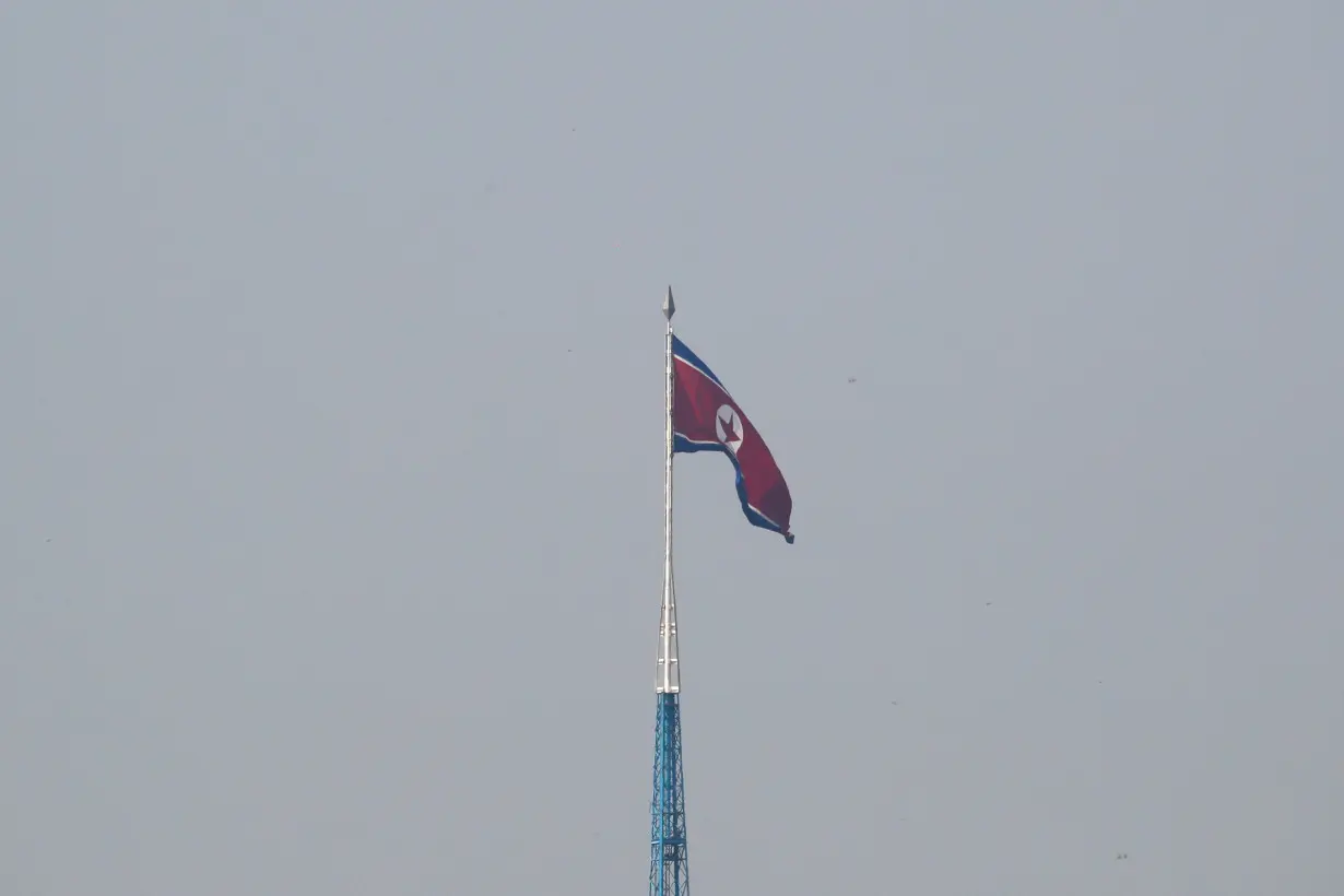 FILE PHOTO: A North Korean flag flutters on top of a tower at North Korea's propaganda village of Gijungdong, as seen from Paju