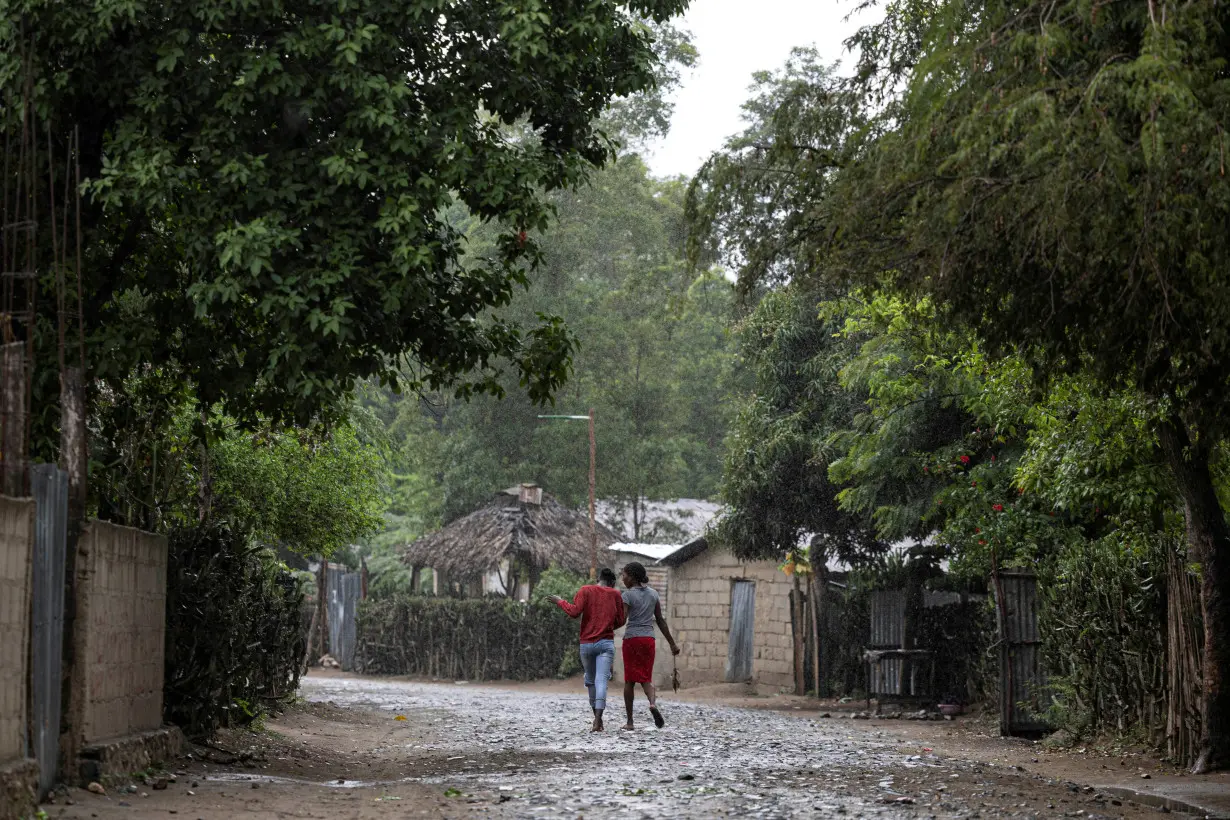 FILE PHOTO: Women walk under the rain in the Malfety neighborhood of Fort Liberte