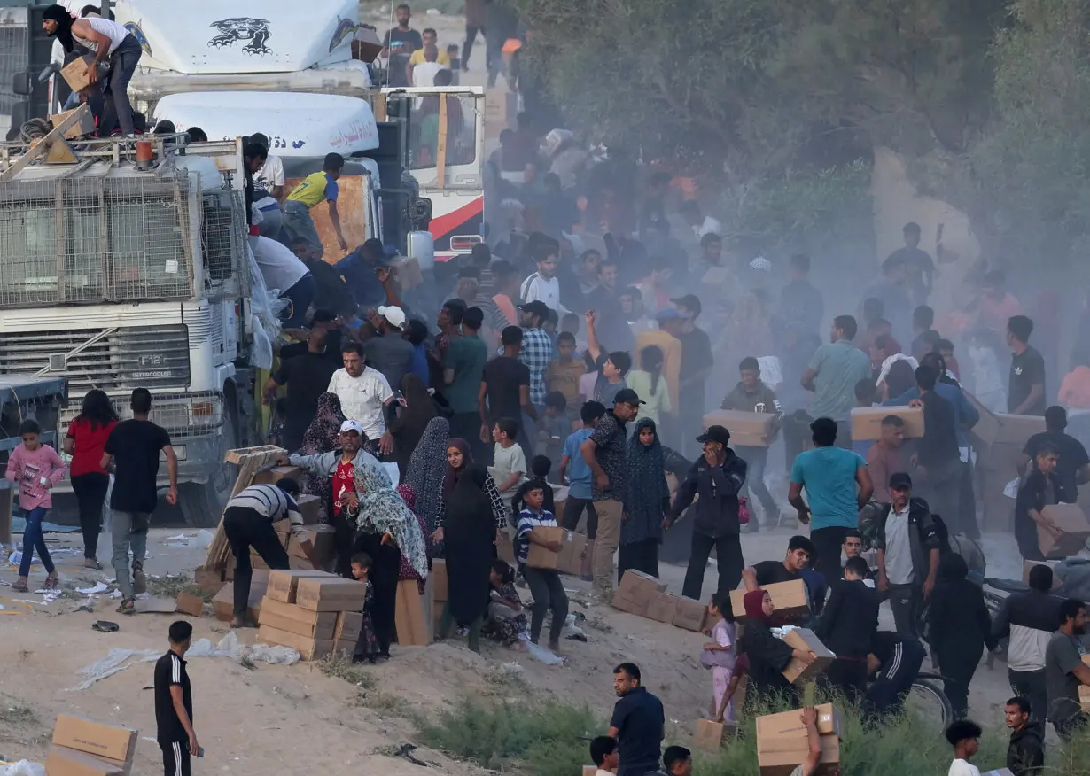 FILE PHOTO: Palestinians climb onto trucks to grab aid that was delivered into Gaza through a U.S.-built pier, as seen from central Gaza Strip