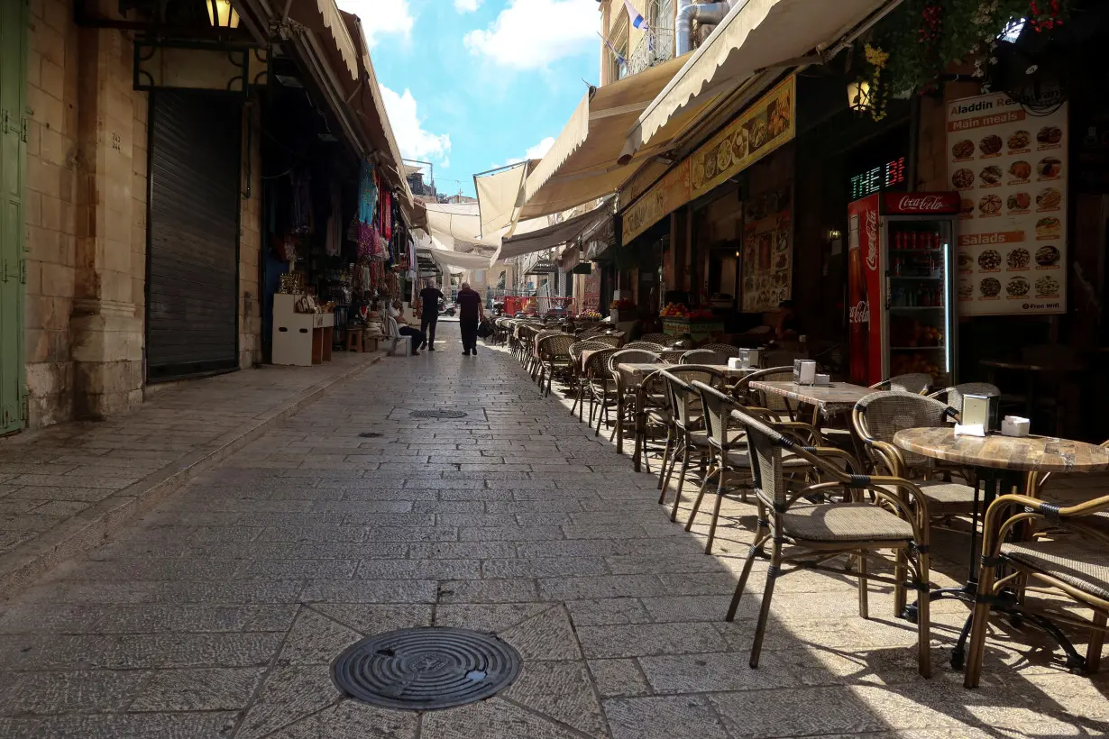 FILE PHOTO: People walk into Jerusalem's Old City via Jaffa Gate, as the conflict wreaks havoc across the tourism sector