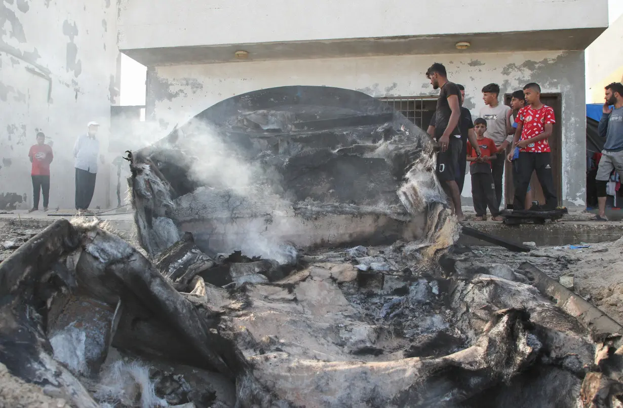 Palestinians inspect boats damaged in Israeli fire, in Rafah in the southern Gaza Strip