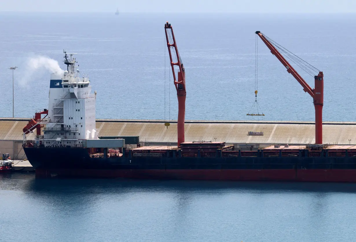 FILE PHOTO: A crane lifts material onto a cargo vessel expected to take aid to Gaza from Cyprus, at the port of Larnaca