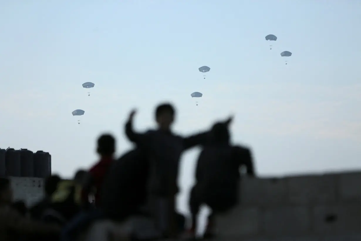 People watch as U.S. military carries out its first aid drop over Gaza, amid the ongoing the conflict between Israel and the Palestinian Islamist group Hamas, in Gaza City