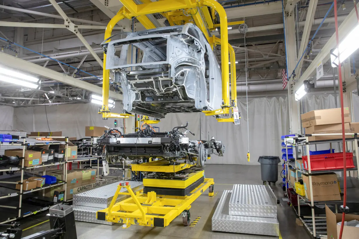 FILE PHOTO: The top hat of a Canoo electric vehicle waits to be attached to an electric car platform at a manufacturing site