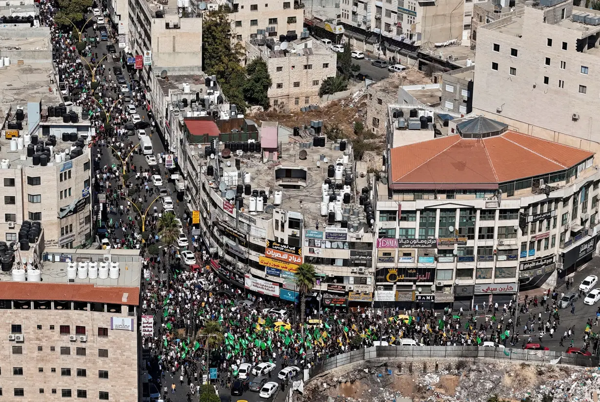 Palestinians take part in a protest following Israeli strikes on Gaza, in Hebron