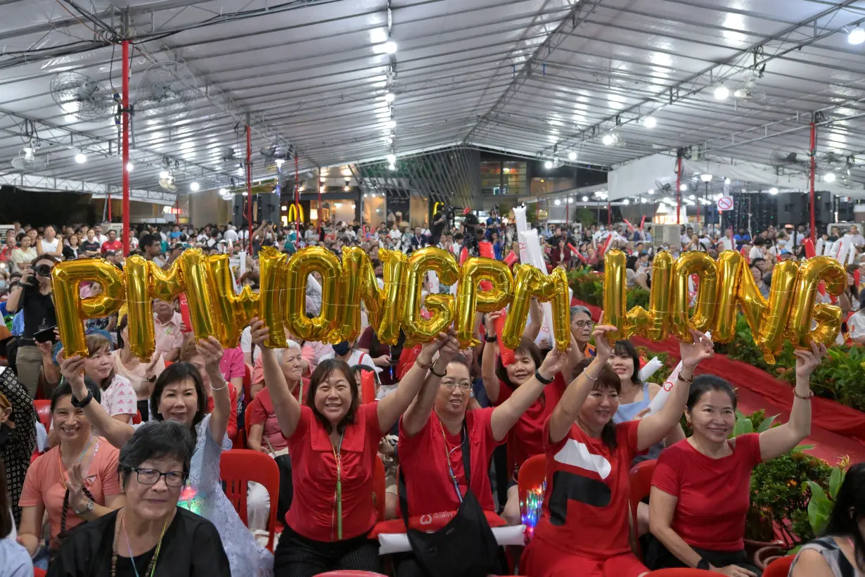 People watch the swearing-in ceremony ceremony of Singapore's fourth Prime Minister, Lawrence Wong, from a community event in Singapore