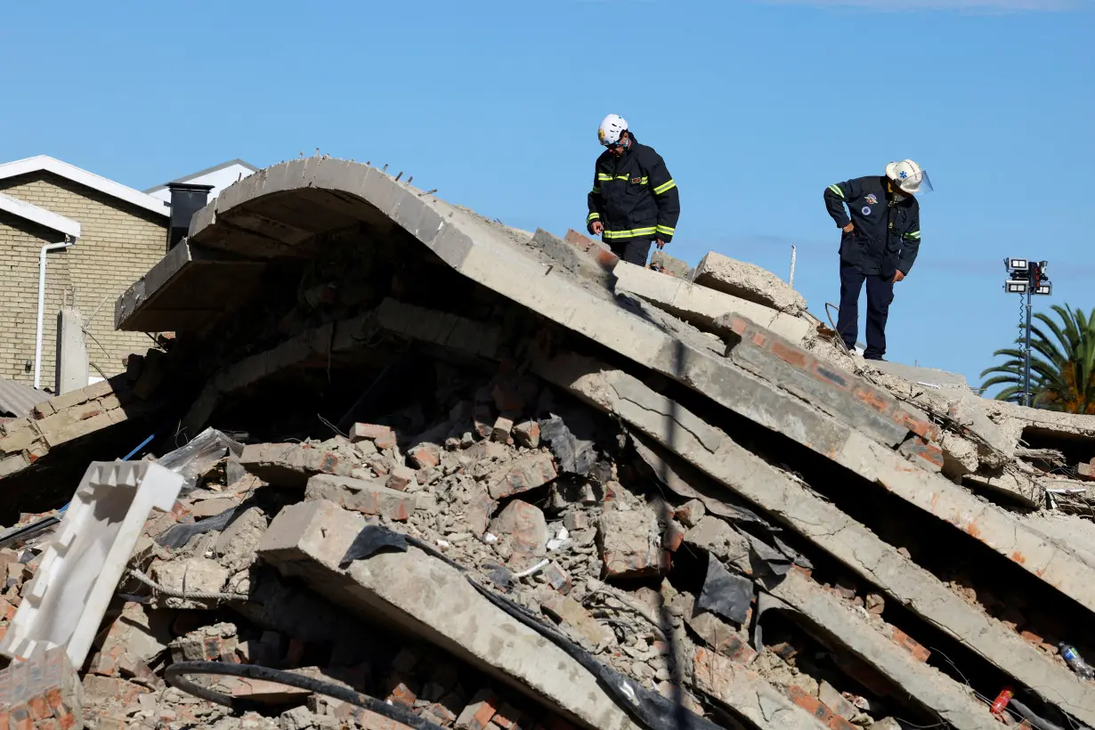 FILE PHOTO: Rescuers work to rescue construction workers trapped under a building that collapsed in George