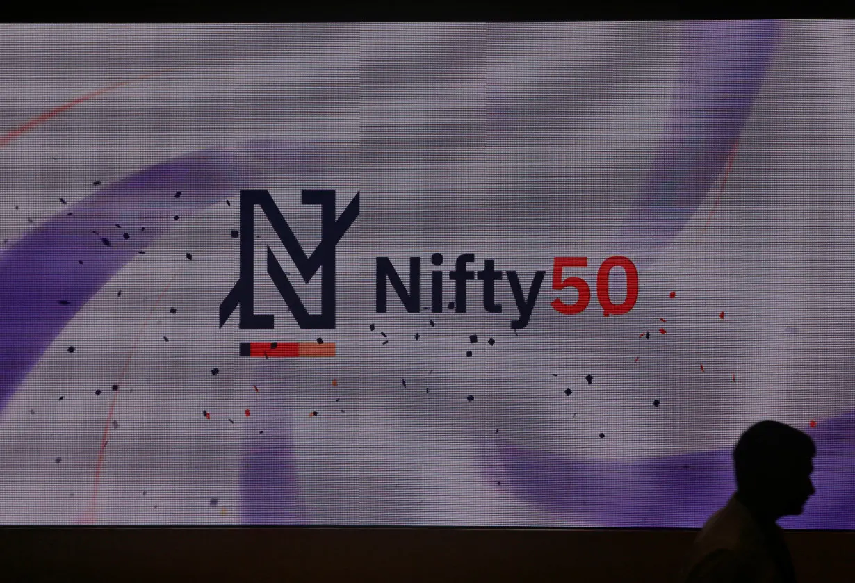 A man walks past a newly launched Nifty Indices logo inside the National Stock Exchange building in Mumbai