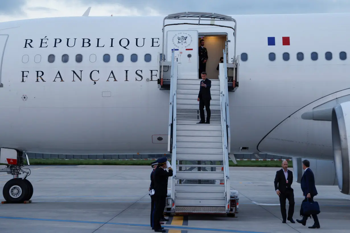 France's President Emmanuel Macron waves as he boards his Presidential plane to travel to the Pacific archipelago of New Caledonia