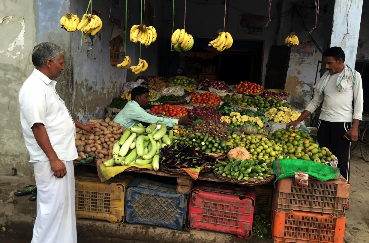 A villager buys vegetables at a shop in village of Sisauli