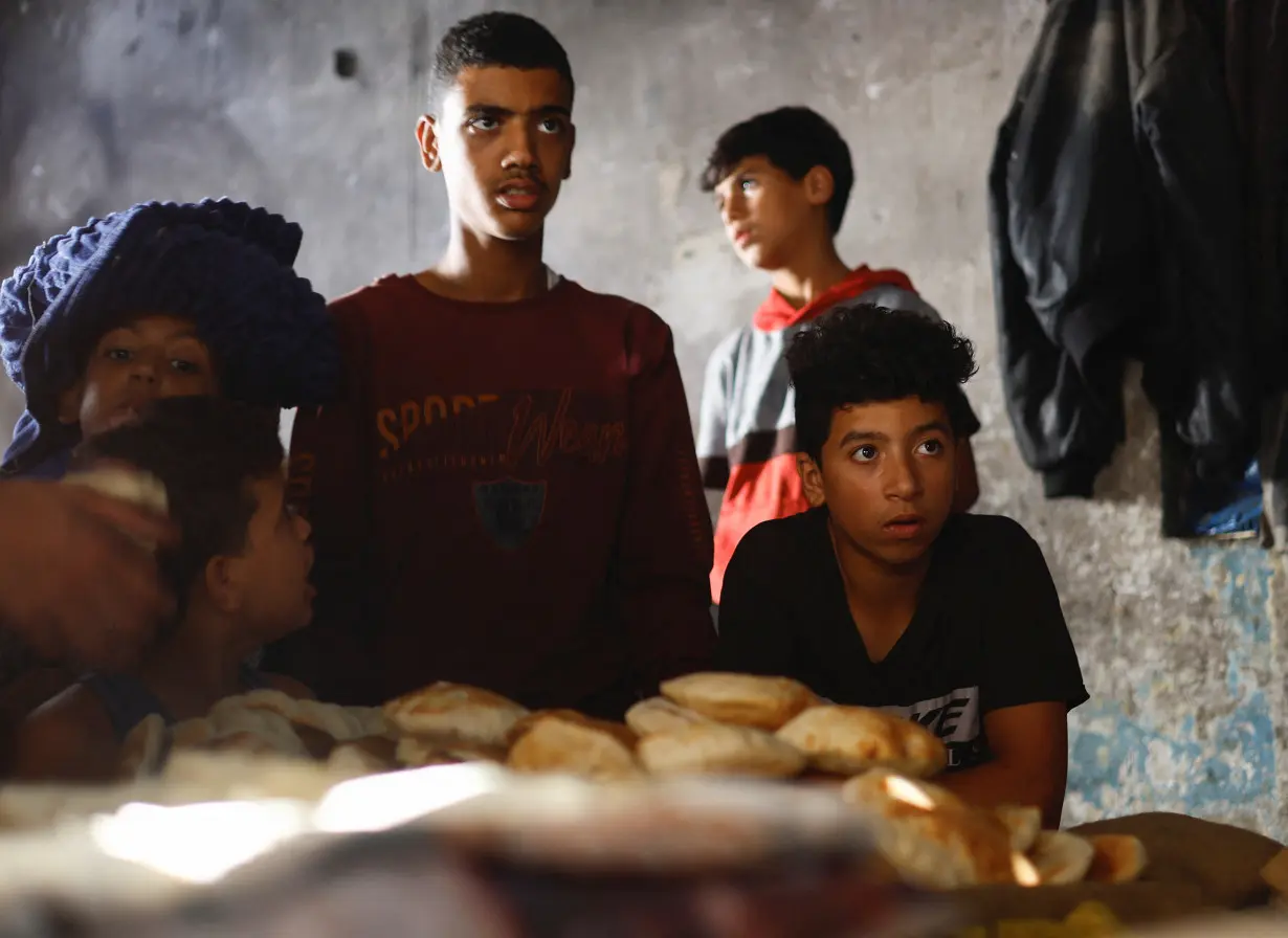 Palestinians wait to bake bread, as the conflict between Hamas and Israel continues