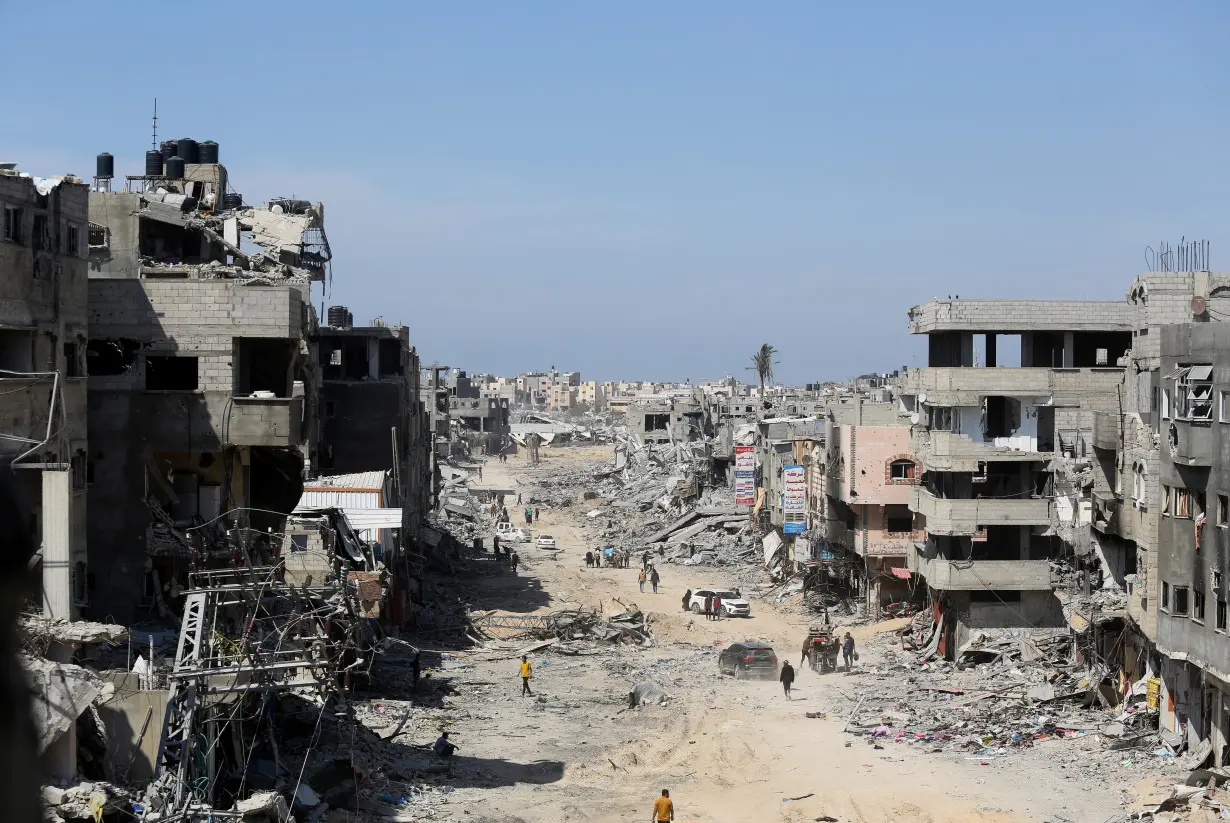 FILE PHOTO: Palestinians inspect destroyed residential buildings in Khan Younis