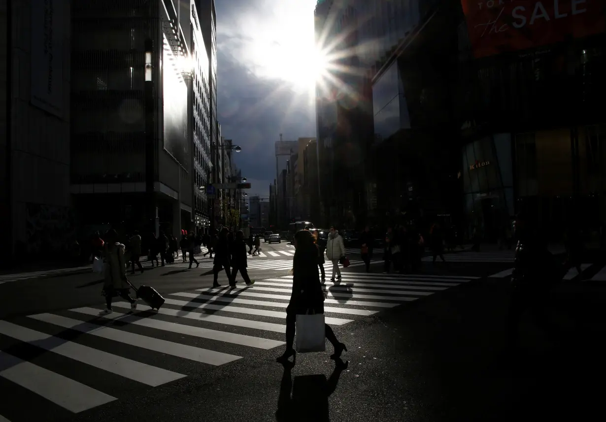 People cross a road at a shopping district in Tokyo