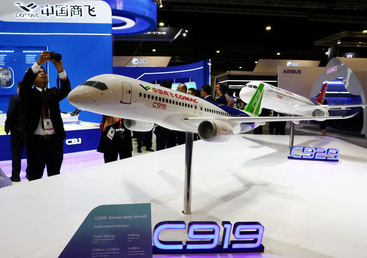 FILE PHOTO: People take photos of a model of the Comac C919 plane during the Singapore Airshow at Changi Exhibition Centre in Singapore