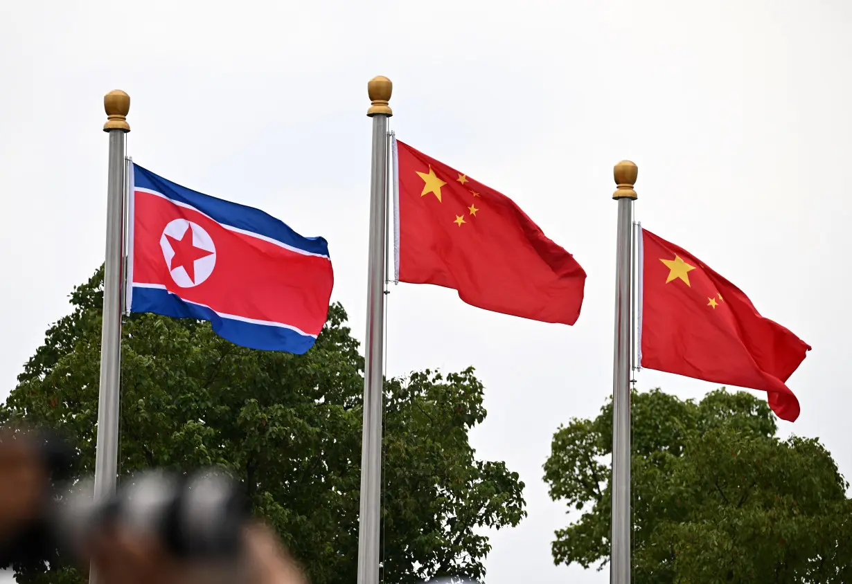 Asian Games - Hangzhou 2022 - China and North Korea flags are seen during the medal ceremony for the Marathon