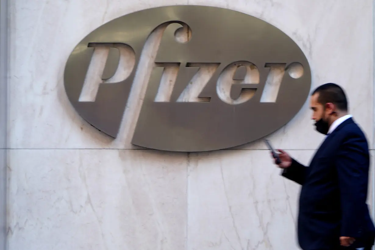 FILE PHOTO: A person walks past the Pfizer Headquarters building