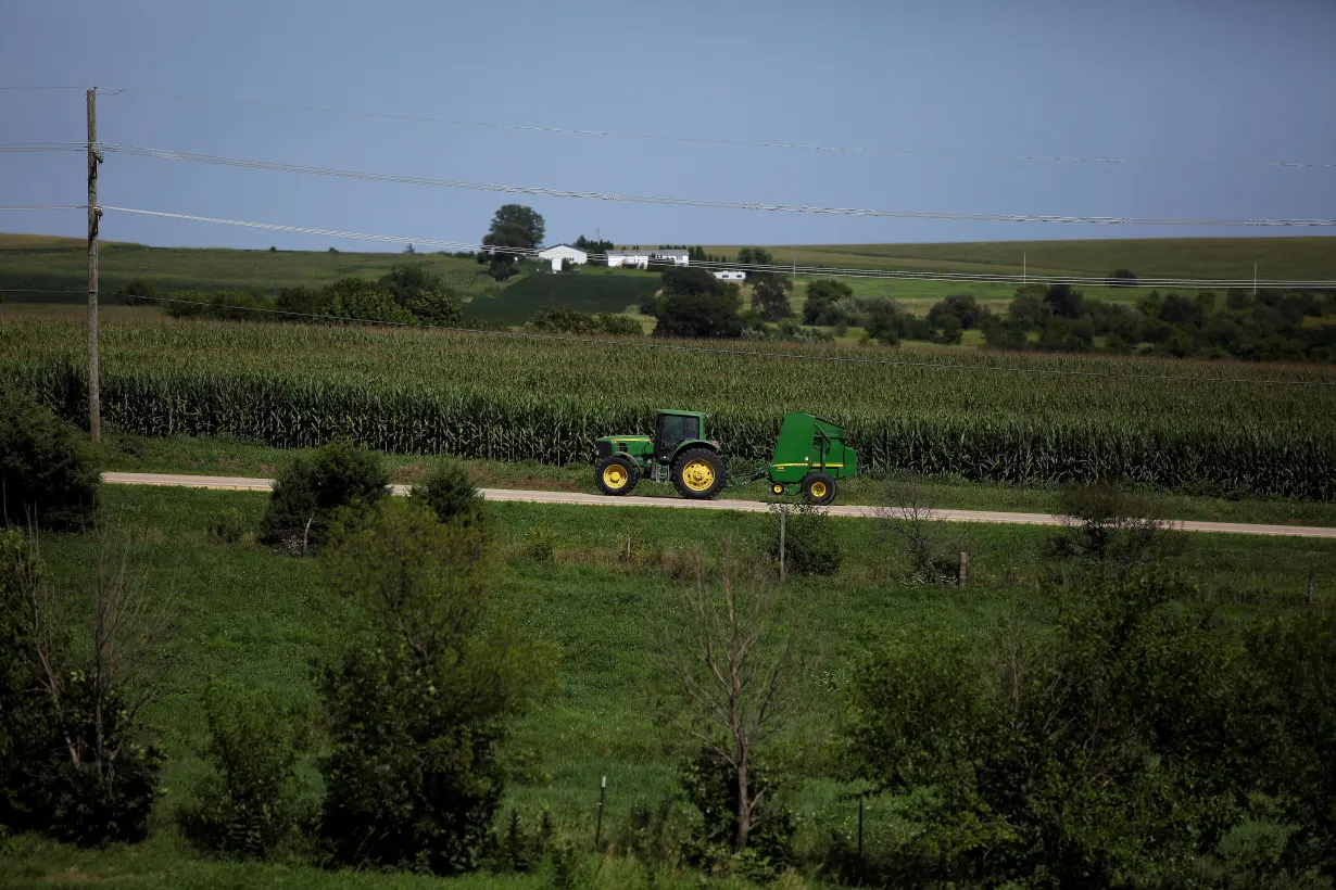 A farmer drives tractor along a road in Pearl City