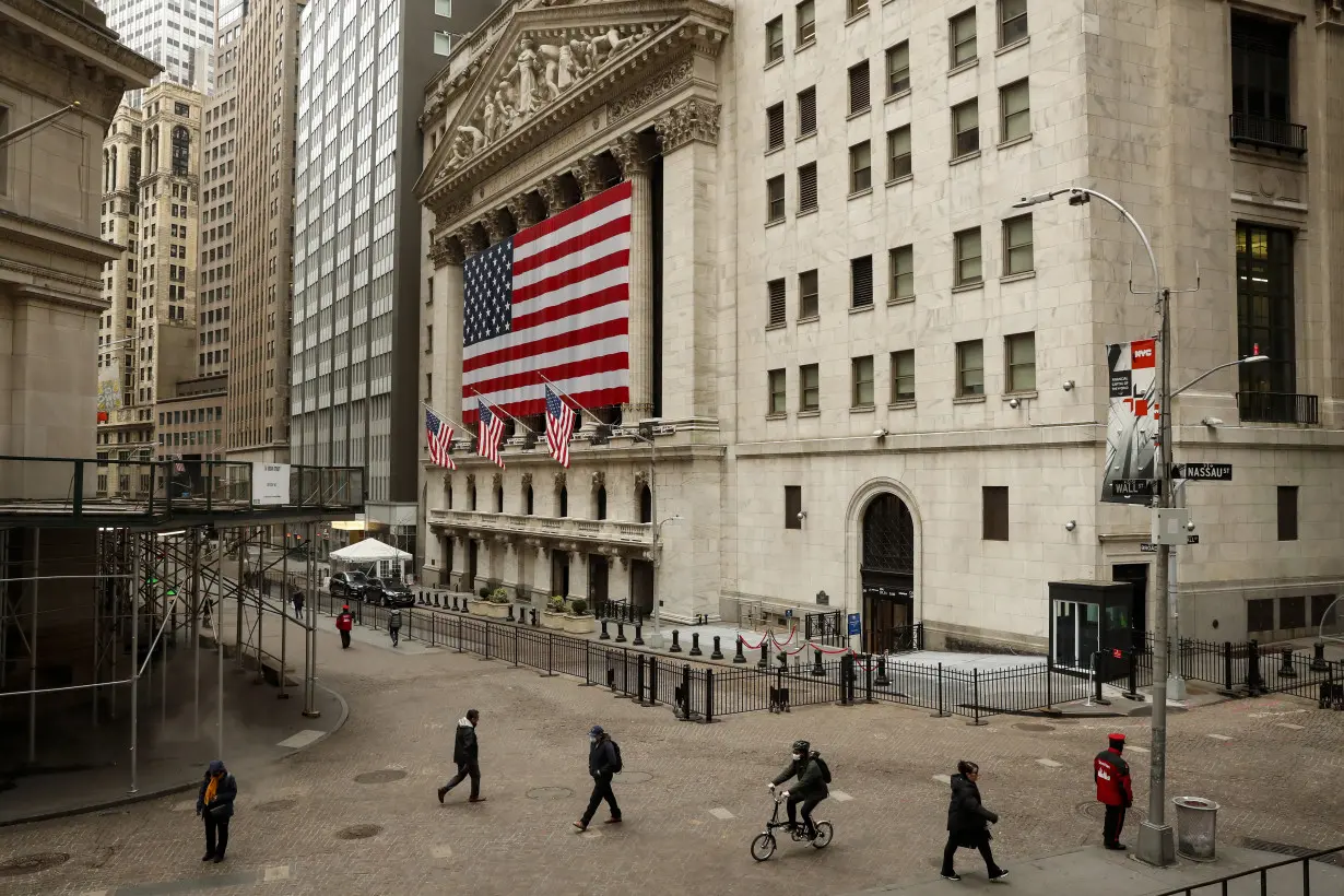 Morning commuters are seen on Wall St. outside the NYSE in New York