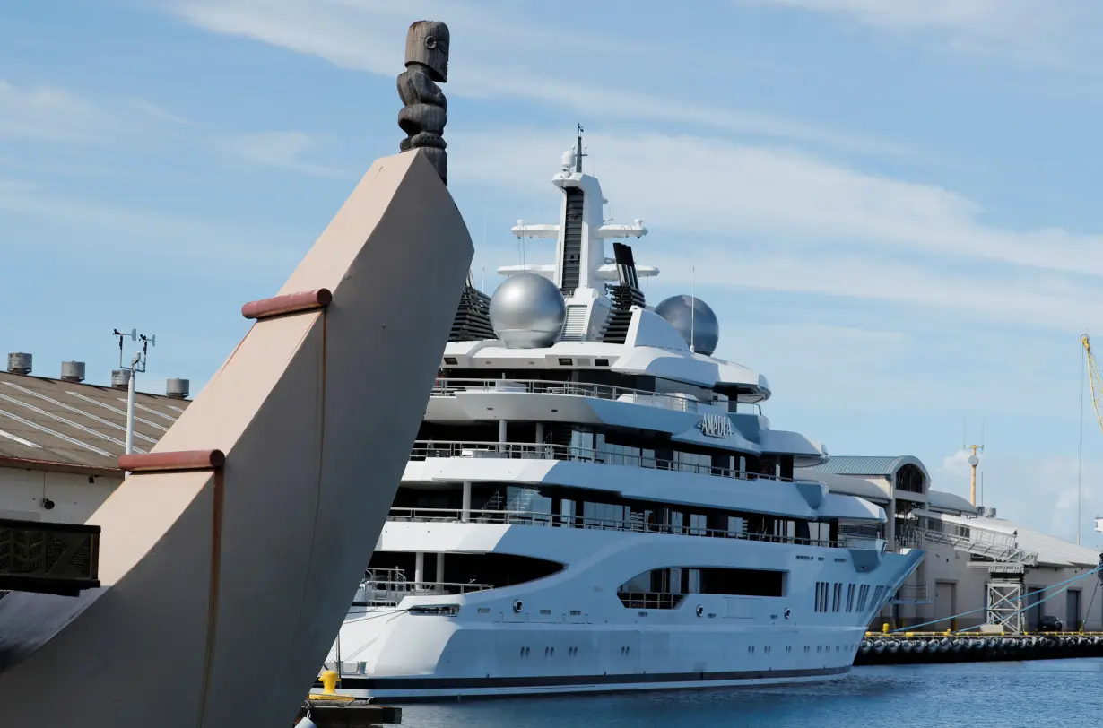 Part of a Hawaii themed cruise ship is seen near the Russian-owned super yacht Amadea which was seized in Fiji by American law enforcement, while it is docked in Honolulu