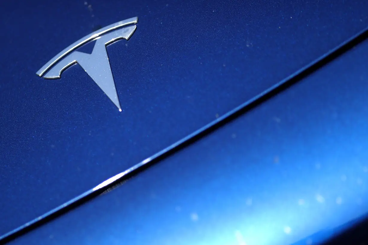 The Tesla logo is seen on a car in Los Angeles