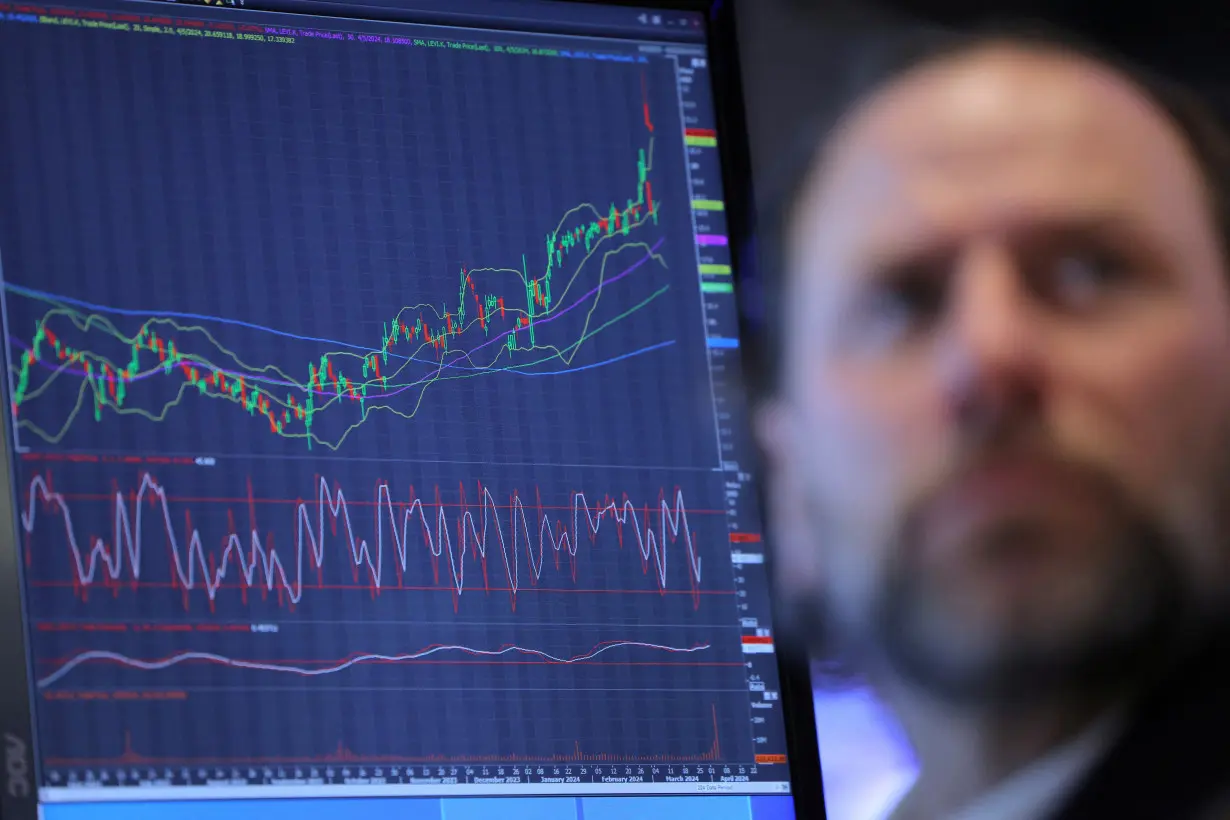 FILE PHOTO: A trader works on the trading floor at the New York Stock Exchange (NYSE) in New York City