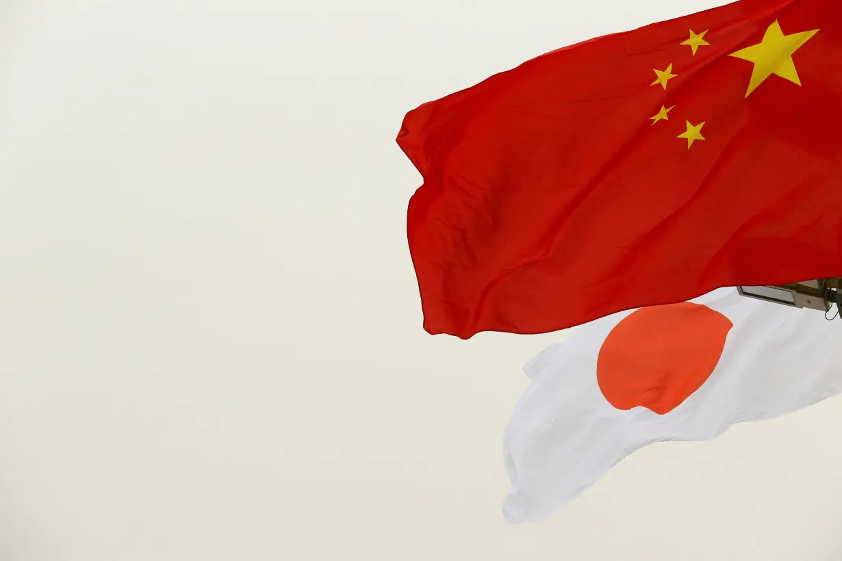 FILE PHOTO: Chinese and Japanese flags flutter in front of the Tiananmen Gate ahead of Japan's Prime Minister Shinzo Abe's visit, in Beijing