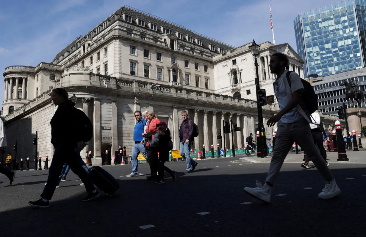 FILE PHOTO: People walk past the Bank of England building, in London