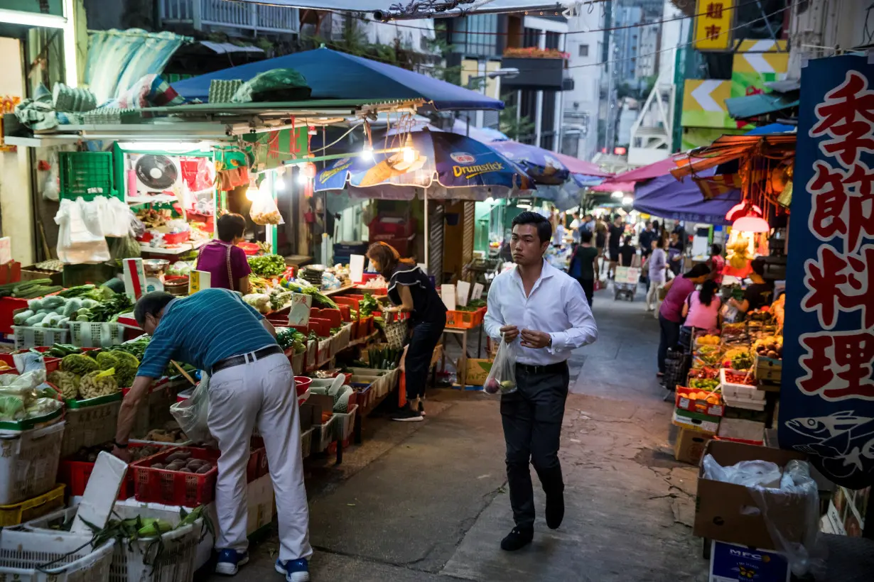 A man walks through a food market in an alley in Sheung Wan in Hong Kong