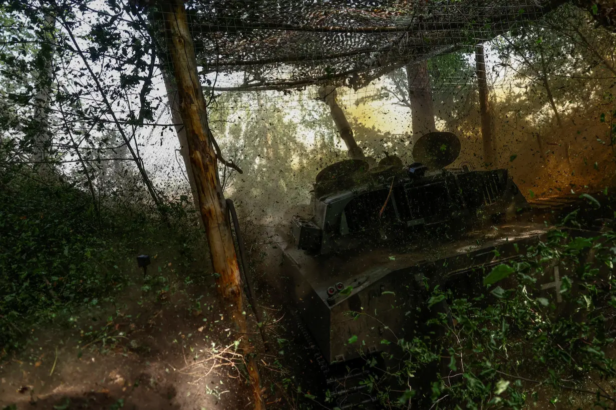 Ukrainian servicemen fire a self-propelled howitzer towards Russian troops in a front line in Kharkiv region