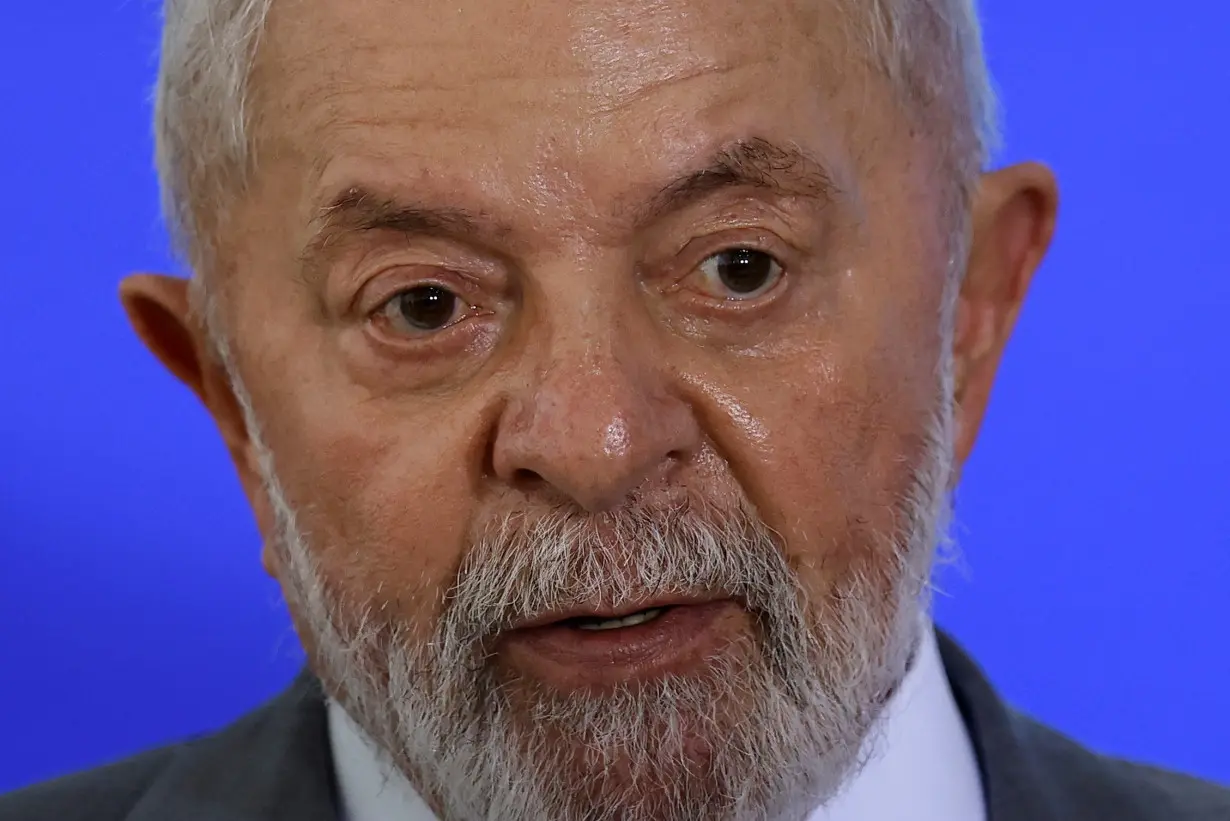 Brazil President Luiz Inacio Lula da Silva reacts during a ceremony to sign the project of the bill to regulate work through ride-hailing apps, at the Planalto Palace in Brasilia