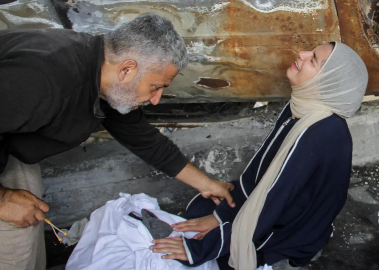 Mourners react next to the bodies of Palestinians killed in an Israeli strike, in Gaza City