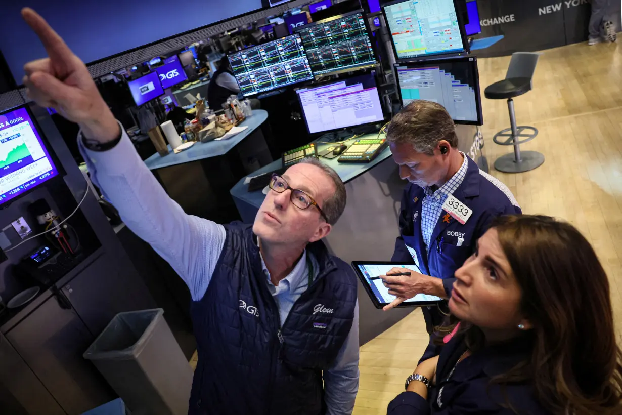 FILE PHOTO: Traders work on the floor of the NYSE in New York