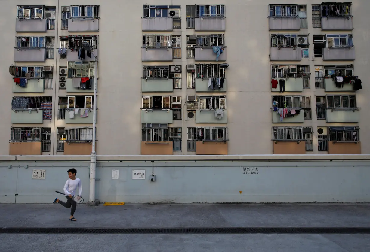 A boy runs past the residential apartments in Hong Kong