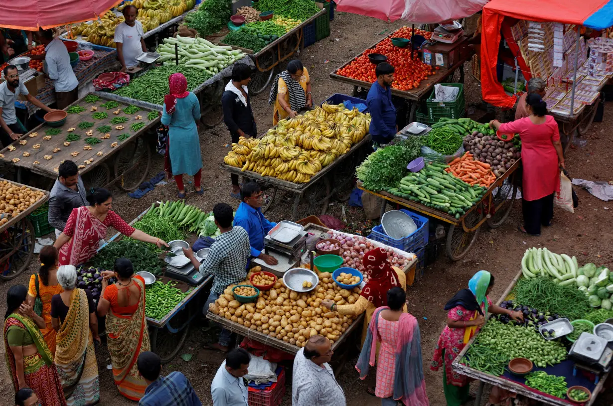 FILE PHOTO: Customers buy fruits and vegetables at an open air evening market in Ahmedabad, India