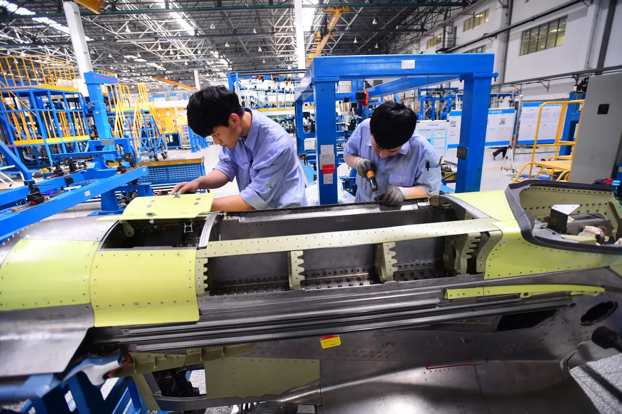 FILE PHOTO: Workers assemble part of the engine assembly for China's self developed C919 passenger aircraft at a factory of Shenyang Aircraft Corporation in Shenyang