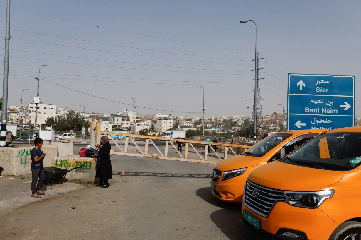 Palestinians cross closed streets on foot in Hebron