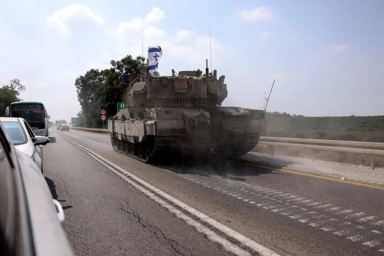 FILE PHOTO: An Israeli tank drives on a road following a mass infiltration by Hamas gunmen from the Gaza Strip, near Sderot