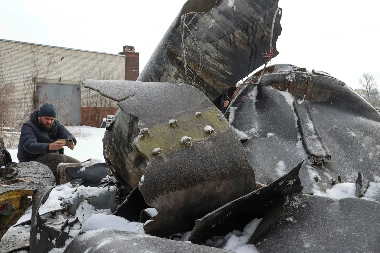 FILE PHOTO: A man photographs parts of an unidentified missile, which Ukrainian authorities believe to be made in North Korea, in Kharkiv