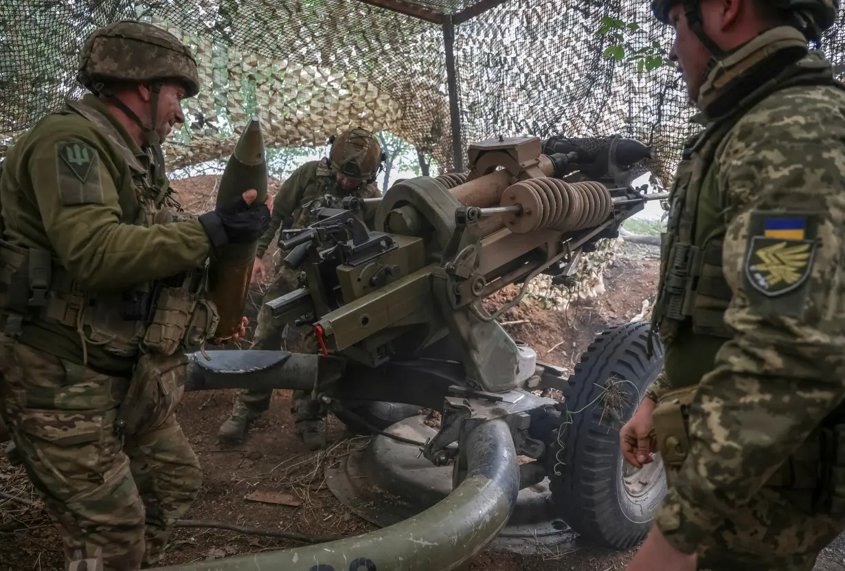 Ukrainian service members fire a L119 howitzer in Donetsk region