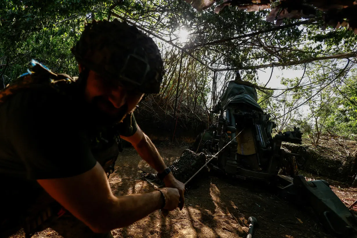 Ukrainian servicemqn fires a howitzer toward Russian troops in Donetsk region