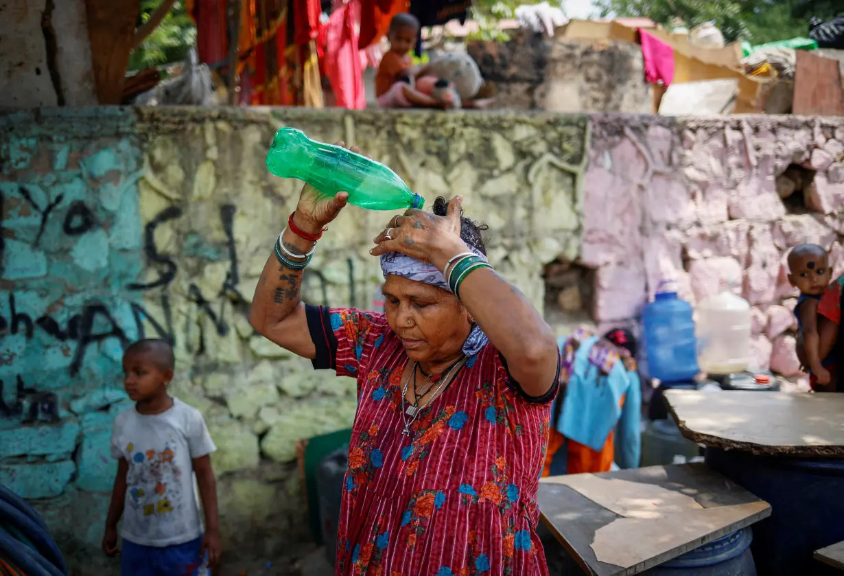 FILE PHOTO: Residents fill their containers with drinking water from a municipal tanker on a hot summer day in New Delhi