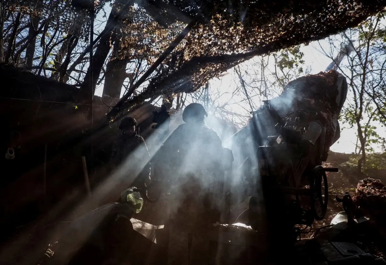 Ukrainian servicemen fire a howitzer towards Russian troops in Donetsk region