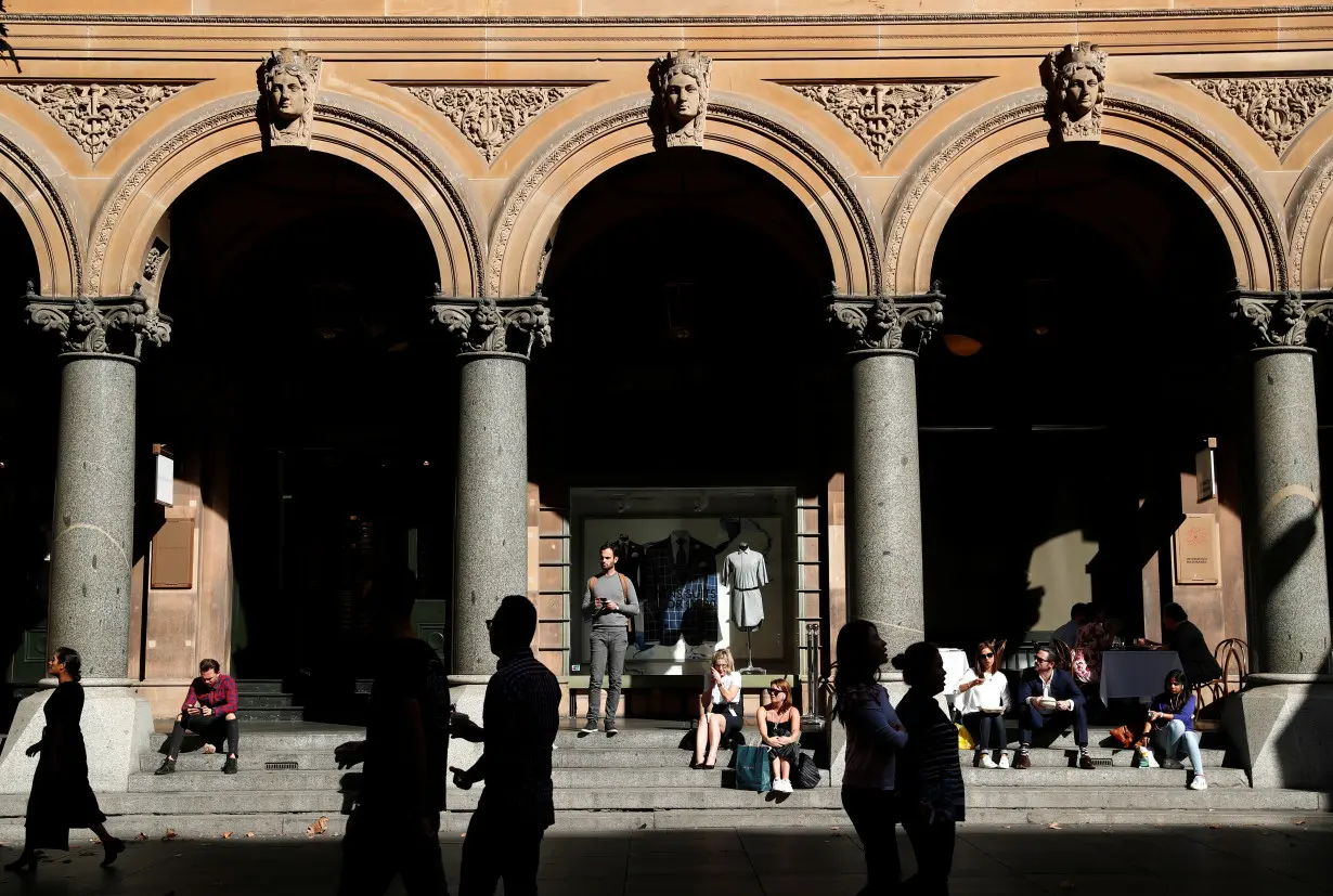 Office workers walk past the General Post Office building during lunchtime in Sydney